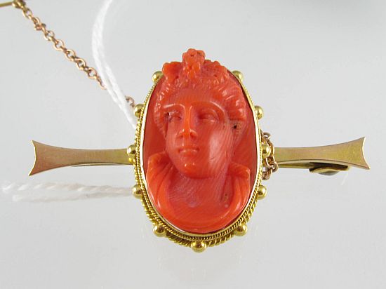 Lot 143. A RED CORAL CAMEO BAR BROOCH bezel-set in 9ct gold. <br>Est $220-280