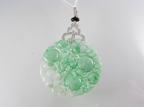 Lot 170. A JADE, ONYX AND DIAMOND PENDANT/ENHANCER with a circular jade carved with fruit and flowers, with diamond and onyx pendant loop; 18ct white gold.<br>Est $950-1150